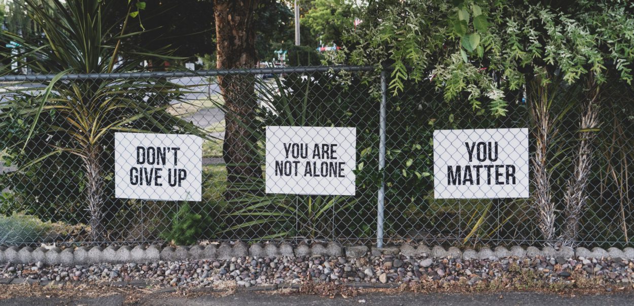 uplifting signs on fence
